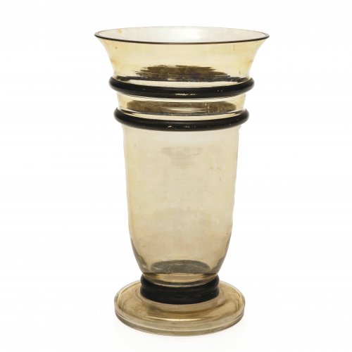 Vase. Entwurf wohl Jean Beck. Farbloses Glas mit Gold schimmernder Beize, Profilringe Schwarzlotbemalung. H. 15 cm.