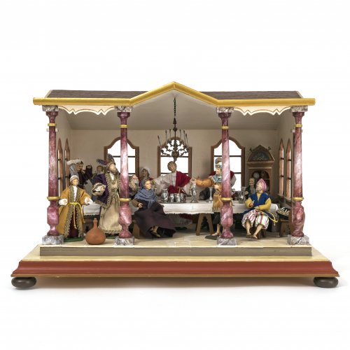 Jahreskrippe mit  14 Figuren, wohl Firma Lang sel. Erben, Oberammergau, neuzeitlich. Tisch und Hockern, Gehäuse in Form eines durchfensterten Giebelhauses mit Loggia. 42 x 66 x 45 cm, H. Figuren 14-18 cm.