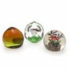 Drei Paperweights. 20. Jh. Bayerischer Wald. Farbloses Glas, eines vielkantig geschliffen. Mit farbigen, floralen Einschmelzungen. Dritter Briefbeschwerer in gelb-grün und honigbraun, mit schimmernden Plättchen im Inneren. Leichte Kratzspuren. H. 9-7,5 cm.