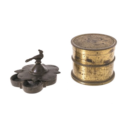 Zwei Dosen. 
1) Messing, vergoldet. Zylinderform mit doppelter Öffnung, darin 20 Lochscheiben. Unvollständig. Kratzspuren. H 6 cm. 
2) Bronze. Dose mit schwenkbarem Deckel und fünfacher Einteilung, Vogelbekrönung. H. 5 cm.