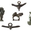 Fünf Amulette. Bronze. Phalli, Ziege, Liegendes Tier, Schälchen. Römisch.