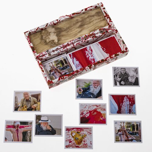 Memory-Spiel. 48 Memory-Karten, mit Fotos aus dem  6-Tage-Spiel von Hermann Nitsch. Holzkästchen gespritzt, dazu ein Stück Original Augenbinde aus dem Orgien-Mysterien-Theater.