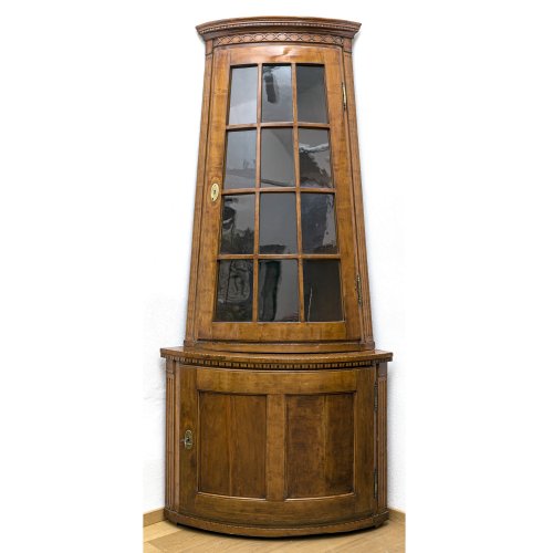 Eckaufsatzvitrine. Berlin um 1800. Birke furniert. H. 244 cm. Schenkeltiefe 114 cm.